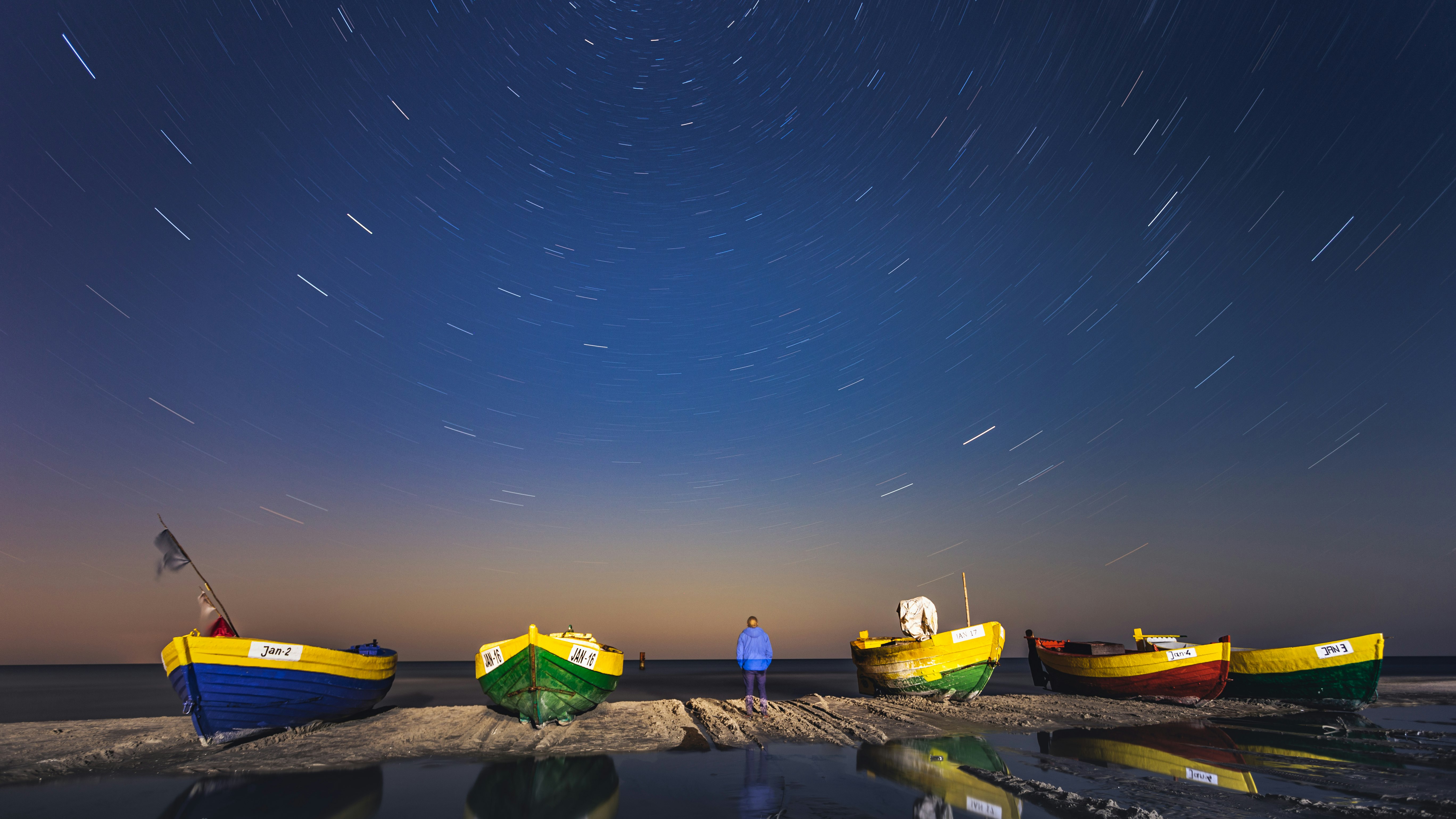 yellow and green plastic boats on brown sand during night time